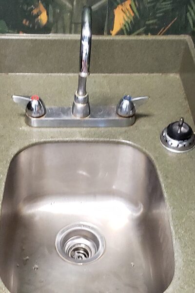 new basket strainer installed in commercial sink replacing leaking drain assembly