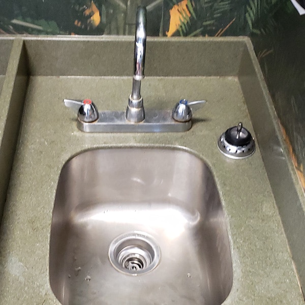 new basket strainer installed in commercial sink replacing leaking drain assembly