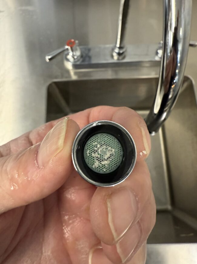 dirty-faucet-aerator-low-water-pressure dirty faucet aerator clogged with debris and mineral buildup