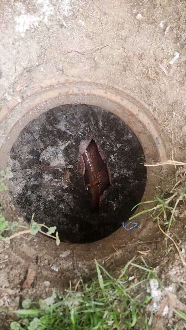 An old clay sewer line had an improvised access hole once used for cabling clogged sewer mains before proper cleanouts were installed.