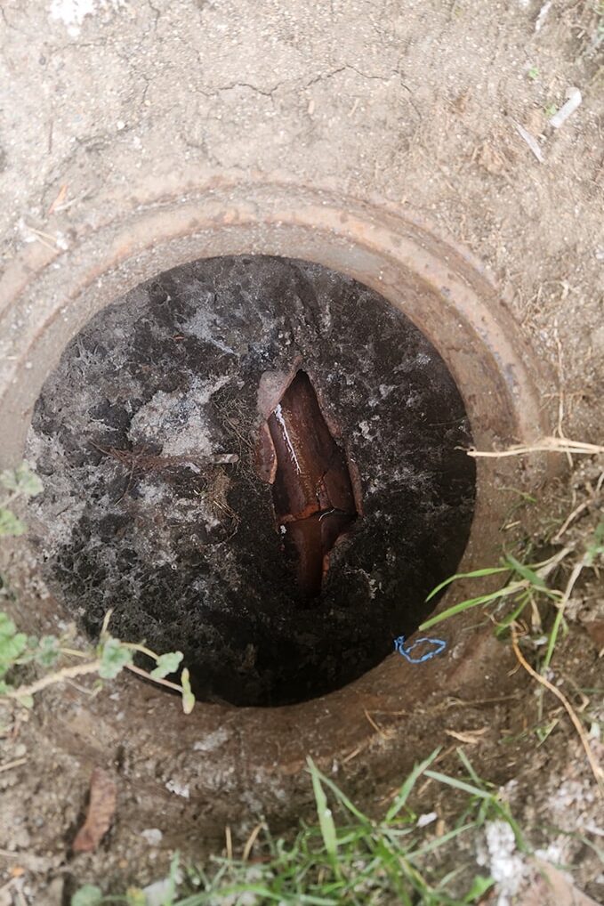 An old clay sewer line had an improvised access hole once used for cabling clogged sewer mains before proper cleanouts were installed.