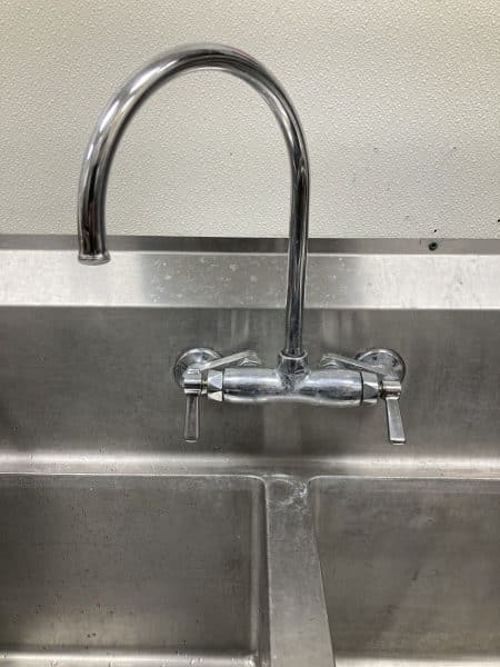 worn kitchen faucet before replacement showing limited reach