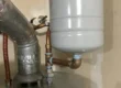 properly installed expansion tank on water heater showing separation from copper piping