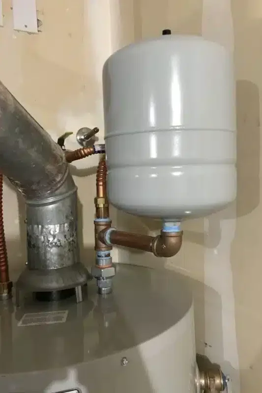 properly installed expansion tank on water heater showing separation from copper piping