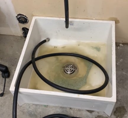 water-heater-draining-sediment-buildup sediment buildup visible while draining residential water heater